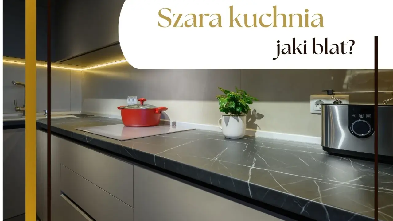 Nowoczesna szara kuchnia z ciemnym blatem, na którym stoi czerwony garnek i srebrny toster.