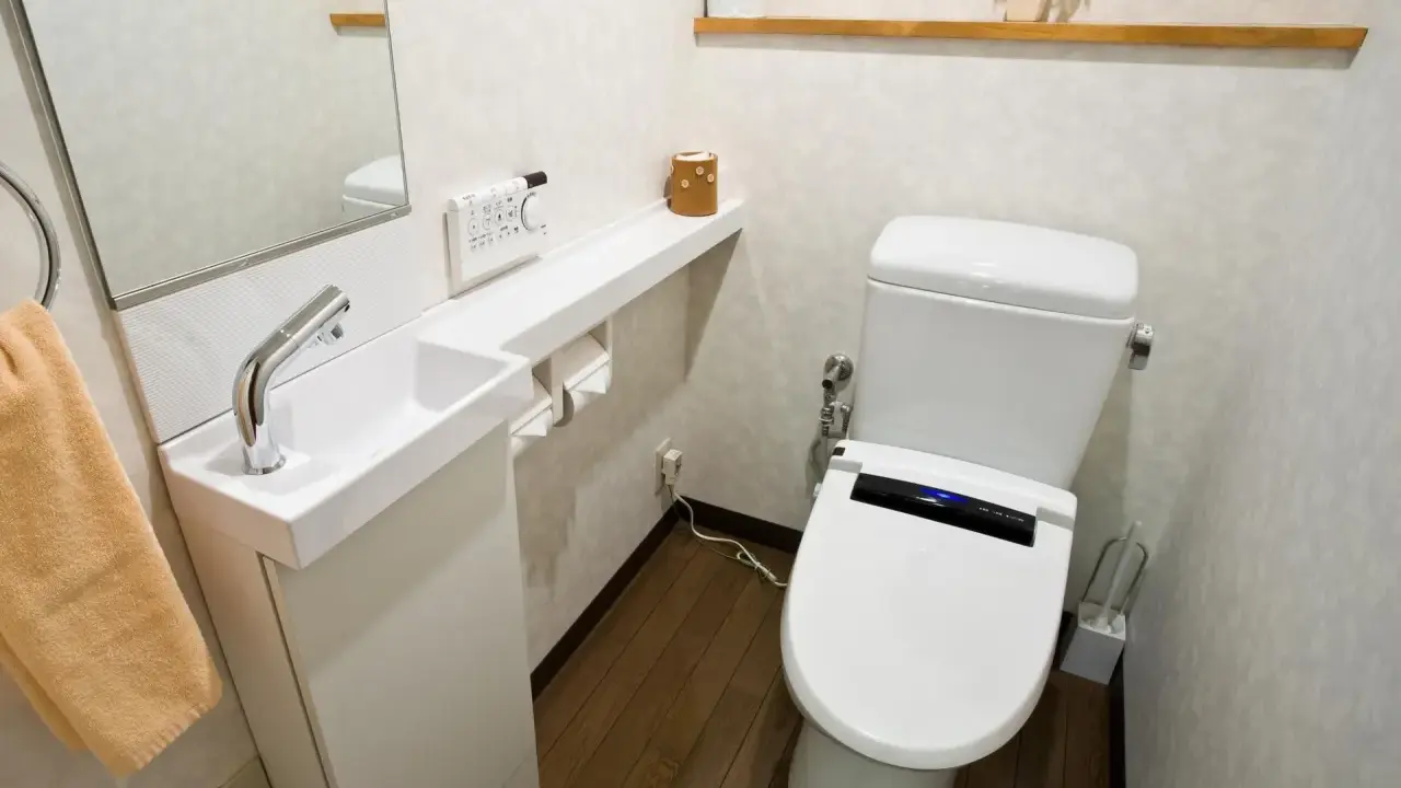 Kompaktowa łazienka z nowoczesną toaletą i małą umywalką. Idealne bardzo małe wc aranżacje dla oszczędnych przestrzeni.