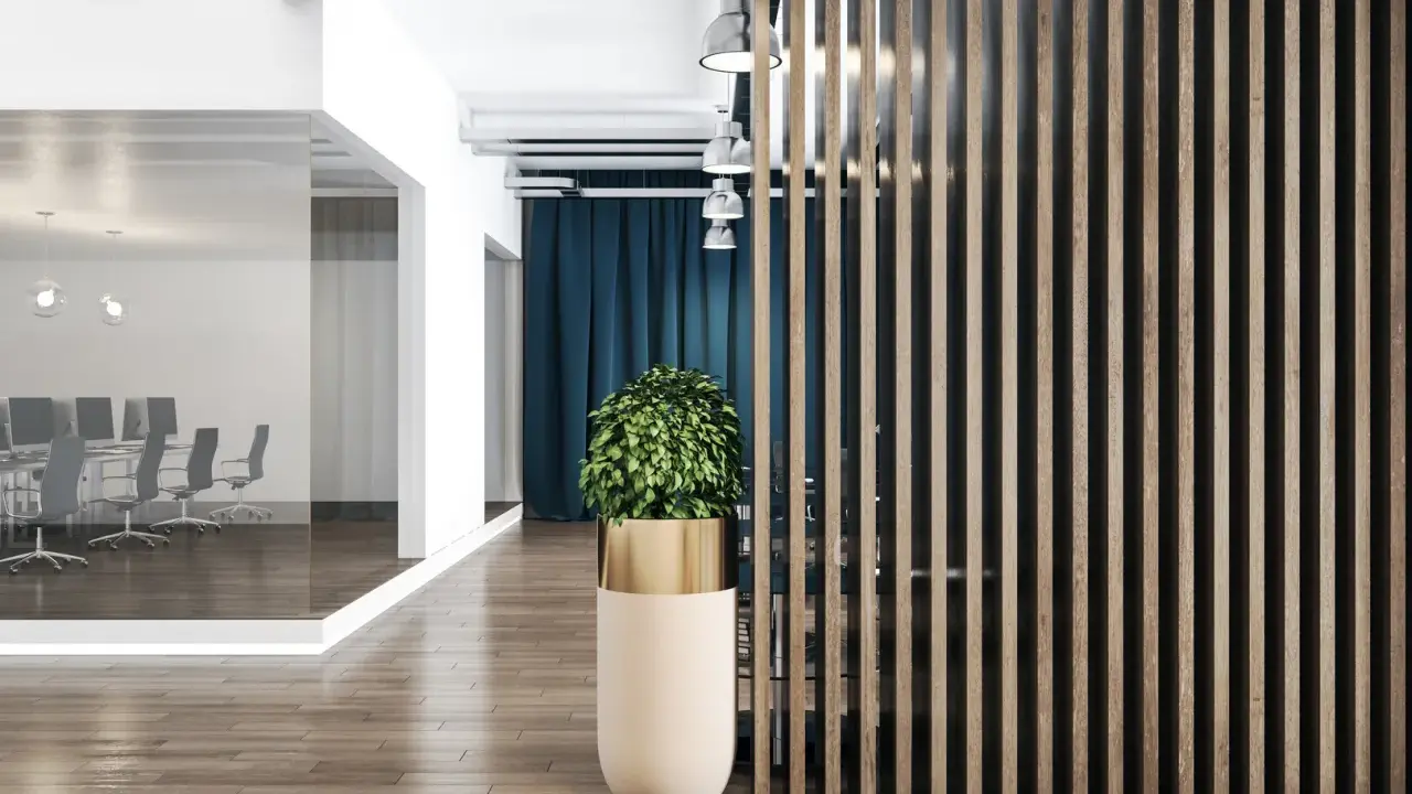 Nowoczesne biuro inspiracje: przeszklona sala konferencyjna, drewniana ściana lamelowa i designerska donica z rośliną tworzą stylową przestrzeń.