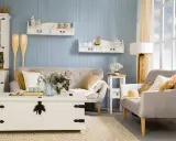 Przytulny salon w stylu morskim. Jasne meble, dekoracje z muszli i drewniane wiosła tworzą nadmorski klimat.
