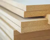 Stos płyt mdf, materiału drewnopochodnego, gotowego do obróbki.