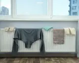 Jak zasłonić kaloryfer pod oknem? Ubrania suszą się na grzejniku, tworząc naturalną osłonę.