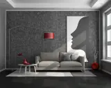Nowoczesny salon z ciemną podłogą, szarą kanapą i abstrakcyjnym obrazem.
