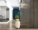 Nowoczesne biuro inspiracje: przeszklona sala konferencyjna, drewniana ściana lamelowa i designerska donica z rośliną tworzą stylową przestrzeń.