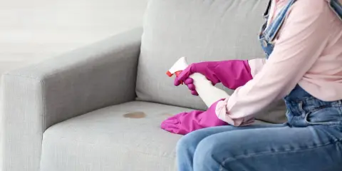 Rękawiczki i spray pomogą Ci dowiedzieć się, jak wyprać kanapę bez odkurzacza. Plama na tapicerce nie stanowi problemu.