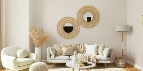 Przytulny, mały pokój inspiracje: jasna sofa, fotele, okrągłe lustra z wikliny, suszone trawy, dywan i lampa.
