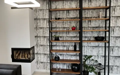 Nowoczesny regał z profili, idealny do salonu. Drewniane półki i czarna metalowa konstrukcja tworzą stylowy mebel.