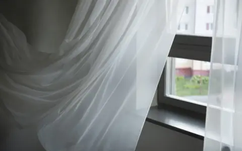 Delikatne, białe firanki falujące przy oknie. Zastanawiasz się, jak wybielić firanki, by znów lśniły czystością?