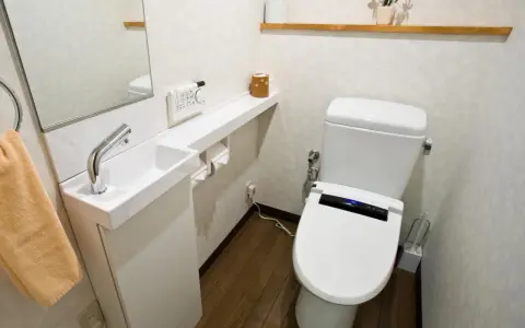 Kompaktowa łazienka z nowoczesną toaletą i małą umywalką. Idealne bardzo małe wc aranżacje dla oszczędnych przestrzeni.