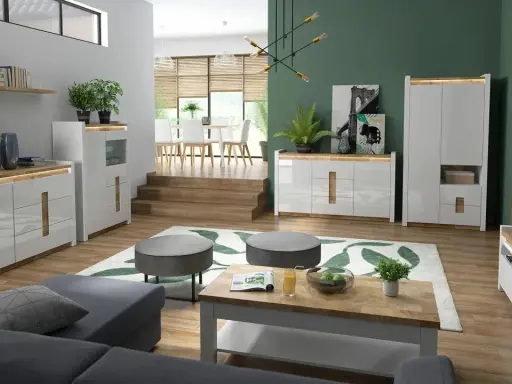 Nowoczesny salon z zielonymi ścianami, białymi meblami i drewnianymi elementami.