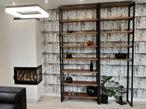 Nowoczesny regał z profili, idealny do salonu. Drewniane półki i czarna metalowa konstrukcja tworzą stylowy mebel.