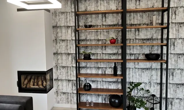 Nowoczesny regał z profili, idealny do salonu. Drewniane półki i czarna metalowa konstrukcja tworzą stylowy mebel.