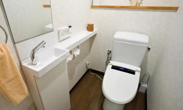 Kompaktowa łazienka z nowoczesną toaletą i małą umywalką. Idealne bardzo małe wc aranżacje dla oszczędnych przestrzeni.
