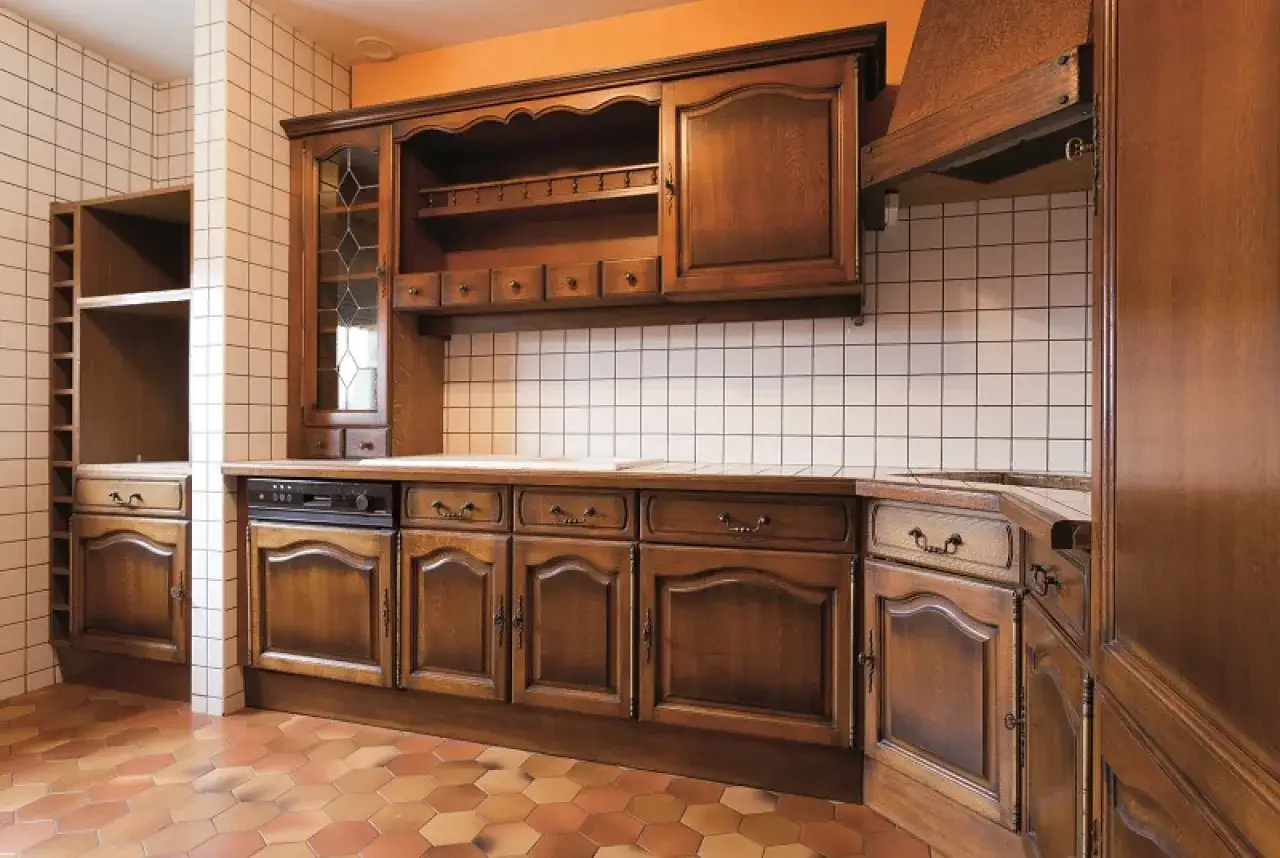 Piękna, drewniana kuchnia w stylu retro. Widoczne są szafki, okap i płytki. Idealna do renowacji mebli kuchennych.