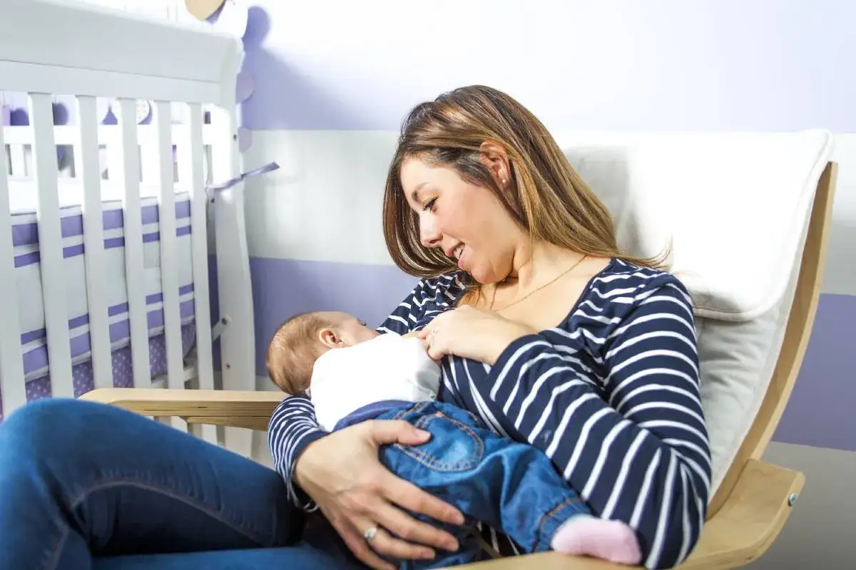Mama karmi dziecko w wygodnym, bujanym fotelu. Idealny fotel do karmienia, który zapewnia komfort i bliskość.