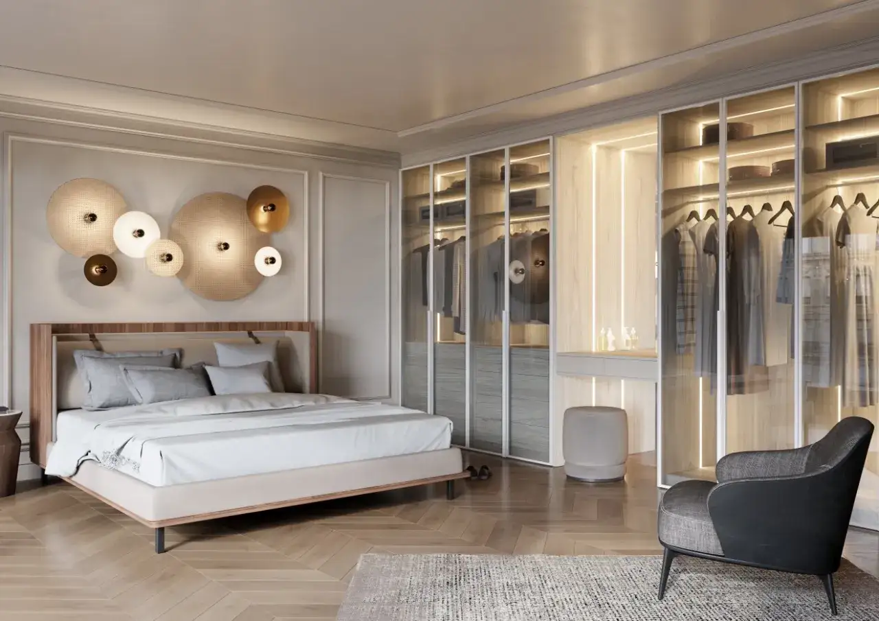 Elegancka, nowoczesna sypialnia glamour z łóżkiem, przeszkloną garderobą i designerskim fotelem.