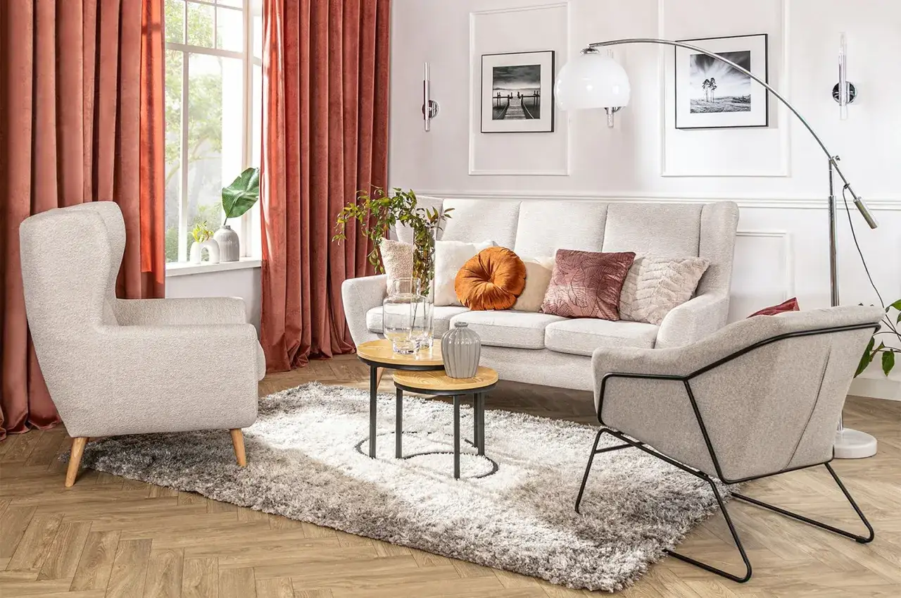 Przytulny salon z dwoma lampami, sofą, fotelami i dywanem.