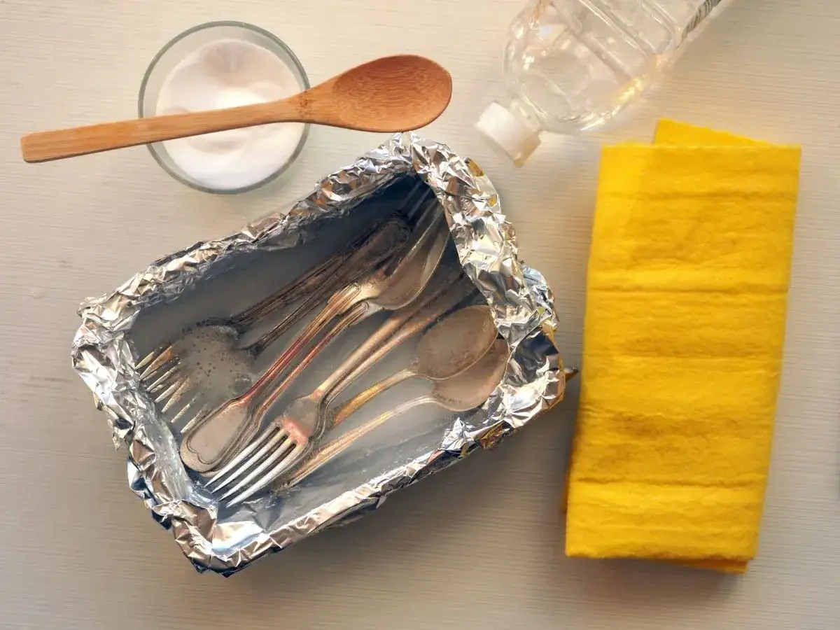 Czyszczenie sztućców sodą w folii aluminiowej. Potrzebne: soda, woda, ściereczka.