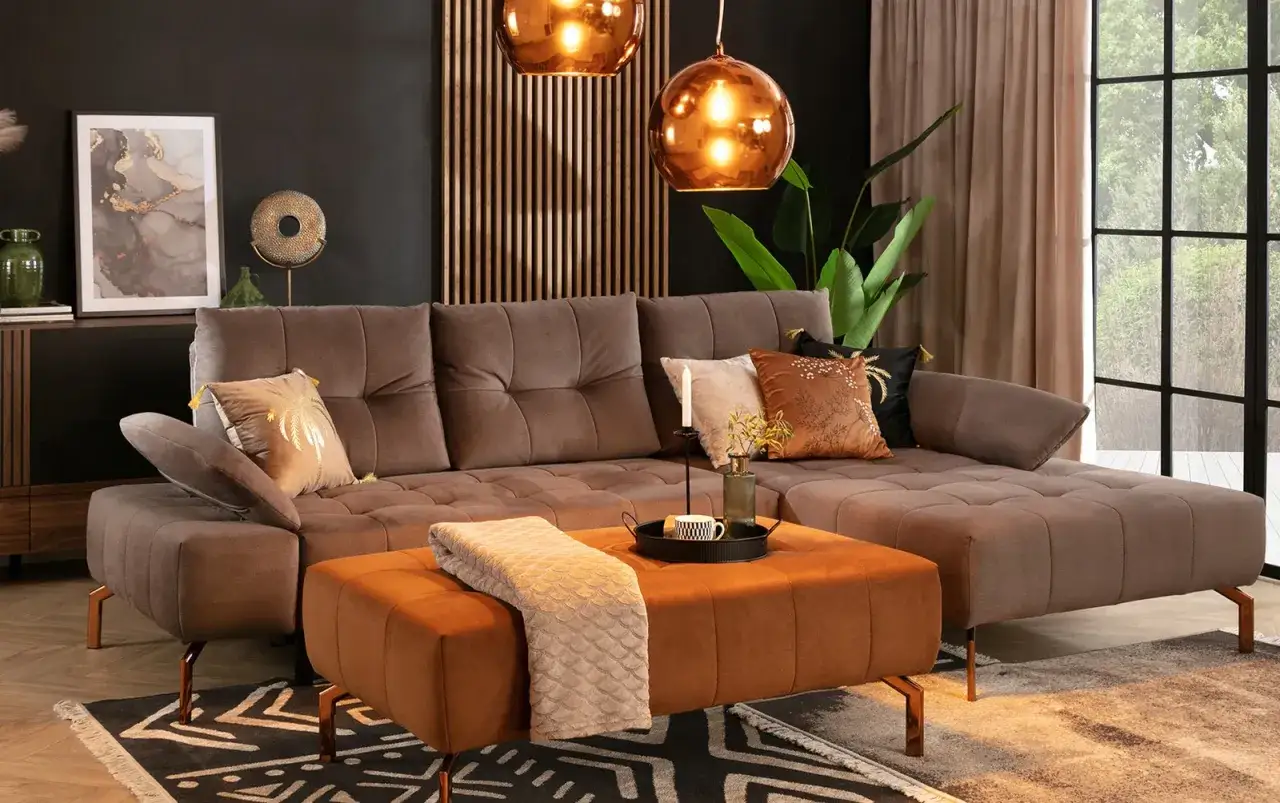 Elegancki salon z brązową sofą i pufą w kolorze karmelowym. Kolor taupe z czym łączyć? Z ciepłymi brązami, złotem i miedzią.