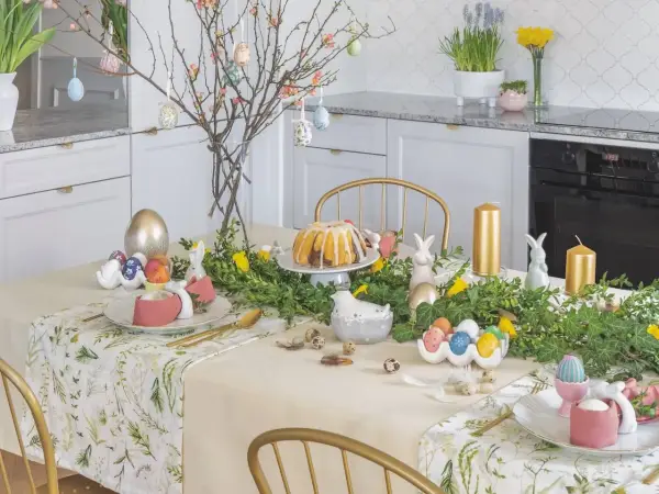 Stół wielkanocny inspiracje: złote pisanki, zajączki, babka i gałązki z ozdobami tworzą wiosenną atmosferę.